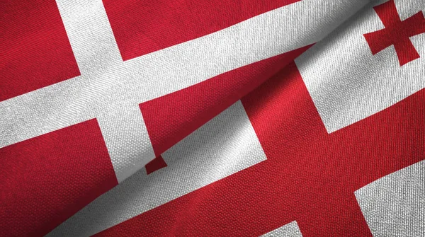 Danemark et Géorgie deux drapeaux tissu textile, texture du tissu — Photo