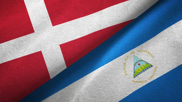 Данія і Нікарагуа два прапори текстильної тканини, тканина текстура — стокове фото