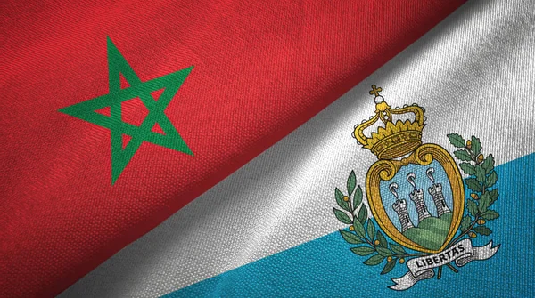 Marokko en San Marino twee vlaggen textiel doek, stof textuur — Stockfoto