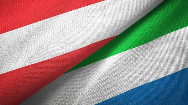 Austria e Sierra Leone due bandiere tessuto, tessitura tessuto — Foto Stock