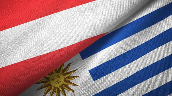 Austria y Uruguay dos banderas tela textil, textura de la tela —  Fotos de Stock