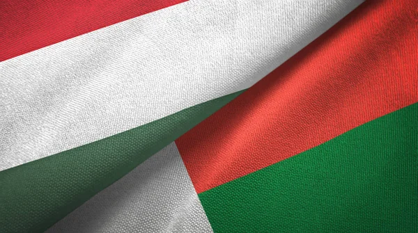 Угорщина і Мадагаскар два прапори текстильної тканини, текстура тканини — стокове фото