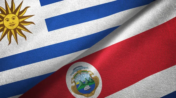 Uruguay y Costa Rica dos banderas de tela textil, textura de tela —  Fotos de Stock