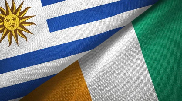 Uruguay och Elfenbenskusten elfenben Coast två flaggor textil tyg textur — Stockfoto