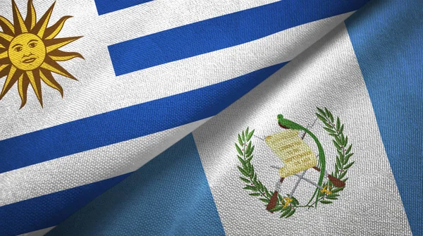 Uruguay y Guatemala dos banderas de tela textil, textura de tela —  Fotos de Stock