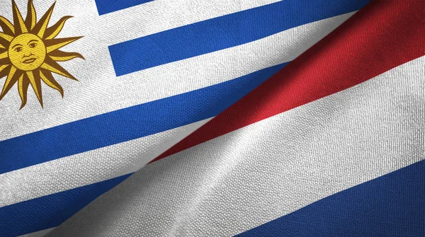 Uruguay und Niederlande zwei Flaggen Textiltuch, Textur — Stockfoto