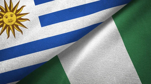 Uruguai e Nigéria duas bandeiras de pano têxtil, textura de tecido — Fotografia de Stock