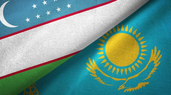 Uzbekistan i Kazachstan dwie flagi tkanina tekstylna, tekstura tkaniny — Zdjęcie stockowe