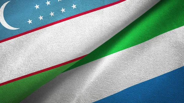 Uzbekistán y Sierra Leona dos banderas tela textil, textura de la tela — Foto de Stock