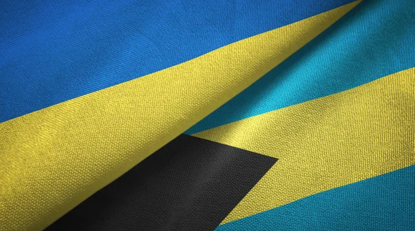 Ucrânia e Bahamas duas bandeiras de pano têxtil, textura de tecido — Fotografia de Stock