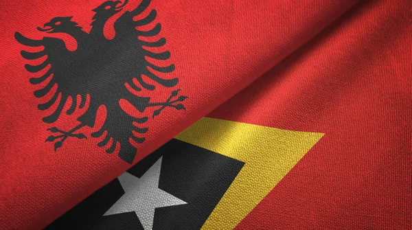 Albanië en Timor-leste Oost-Timor twee vlaggen textiel doek, stof textuur — Stockfoto