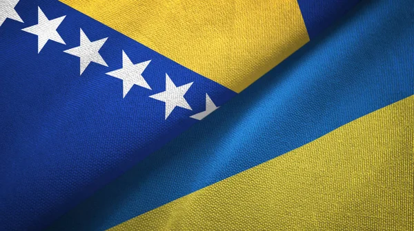Bosnia y Herzegovina y Ucrania dos banderas tela textil, textura de la tela — Foto de Stock