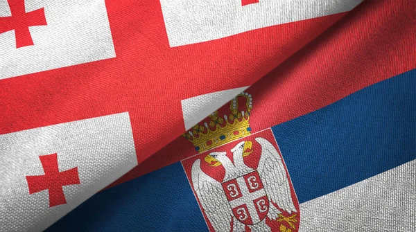 Georgia y Serbia dos banderas tela textil, textura de la tela —  Fotos de Stock
