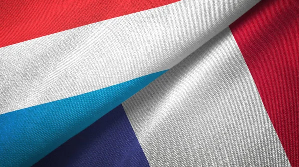 Luxemburgo e França duas bandeiras pano têxtil, textura de tecido — Fotografia de Stock