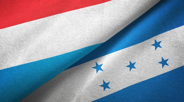 Luxembourg et Honduras deux drapeaux tissu textile, texture du tissu — Photo