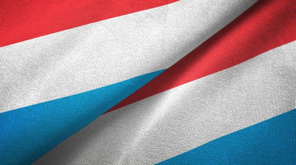 Luxemburgo duas bandeiras pano têxtil, textura de tecido — Fotografia de Stock