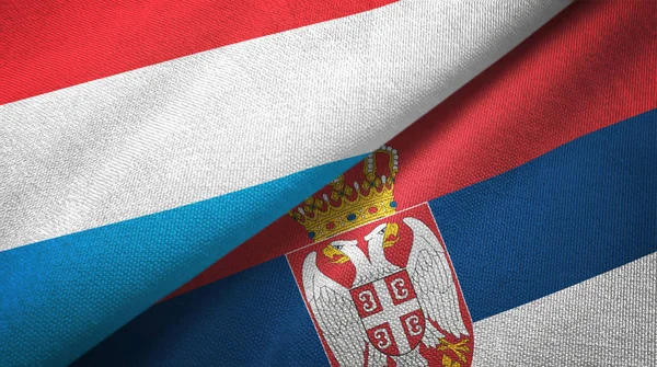 Luxemburg und Serbien zwei Flaggen Textiltuch, Textilstruktur — Stockfoto