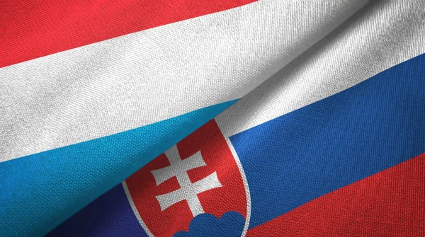 Люксембург и Словакия два флага текстильная ткань, текстура ткани — стоковое фото