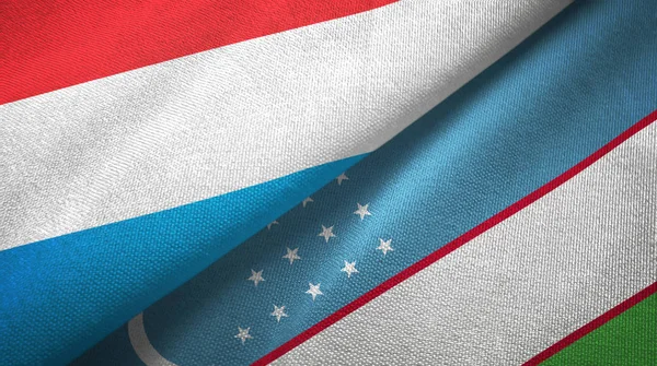 Luxemburg en Oezbekistan twee vlaggen textiel doek, weefsel textuur — Stockfoto