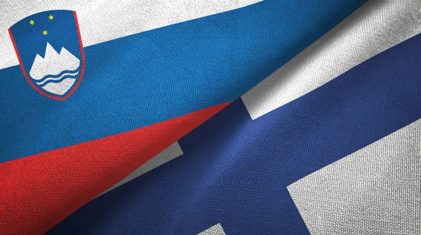 Szlovénia és Finnország két zászló textil ruhával, szövet textúra — Stock Fotó