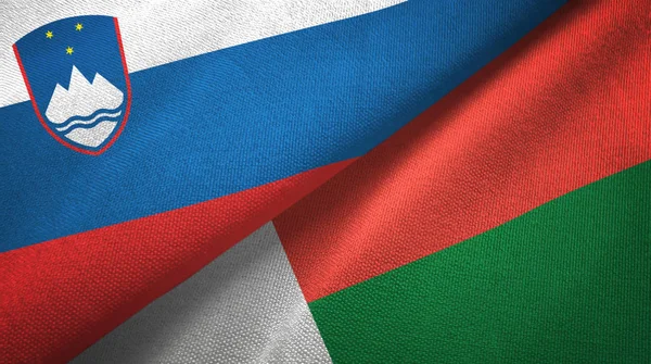 Eslovenia y Madagascar dos banderas tela textil, textura de la tela — Foto de Stock