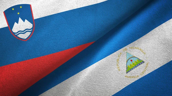 Slovinsko a Nikaragua dvě vlajky textilní tkaniny, textura textilií — Stock fotografie
