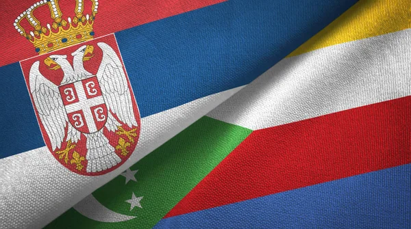 Serbia y Comoras dos banderas tela textil, textura de la tela —  Fotos de Stock