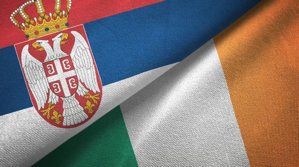 Serbia i Irlandia dwie flagi tkanina tekstylna, tekstura tkaniny — Zdjęcie stockowe