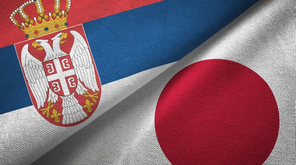 Serbia i Japonia dwie flagi tkanina tekstylna, tekstura tkaniny — Zdjęcie stockowe