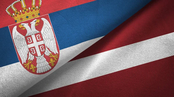 Serbia y Letonia dos banderas tela textil, textura de la tela —  Fotos de Stock