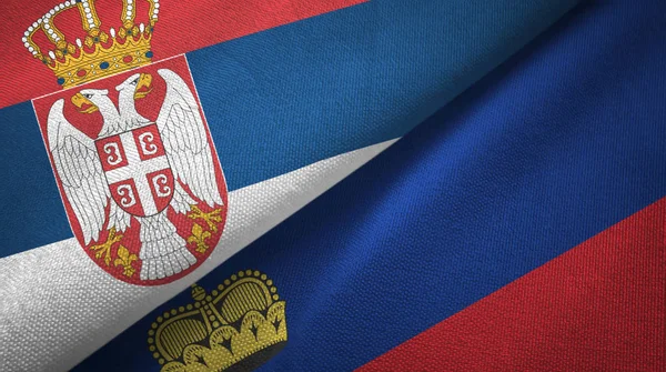 Sérvia e Liechtenstein duas bandeiras de pano têxtil, textura de tecido — Fotografia de Stock