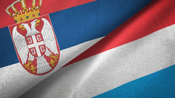 Serbien och Luxemburg två flaggor textil tyg, tyg konsistens — Stockfoto