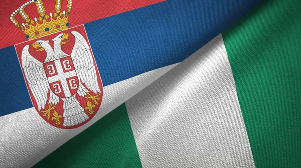 Serbien och Nigeria två flaggor textil tyg, tyg konsistens — Stockfoto