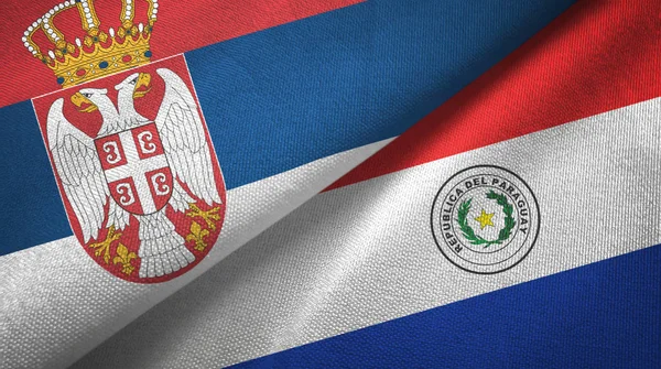 Serbien och Paraguay två flaggor textil tyg, tyg konsistens — Stockfoto