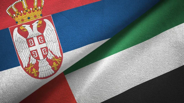 Serbia i Zjednoczone Emiraty Arabskie dwie flagi tkanina tekstylna, tekstura tkaniny — Zdjęcie stockowe