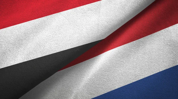 Yémen et Pays-Bas deux drapeaux tissu textile, texture du tissu — Photo
