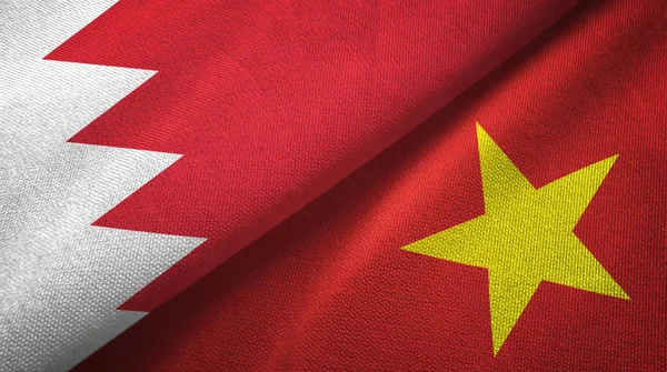 Bahrain och Vietnam två flaggor textil trasa, tyg konsistens — Stockfoto