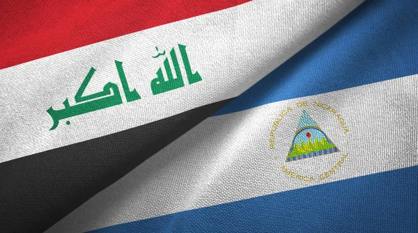 Iraque e Nicarágua duas bandeiras de pano têxtil, textura de tecido — Fotografia de Stock