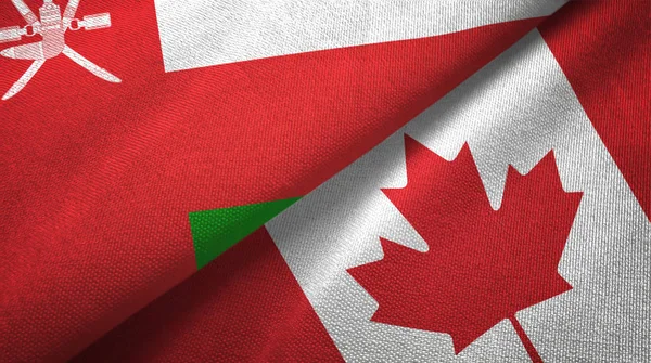 Omán y Canadá dos banderas tela textil, textura de la tela — Foto de Stock