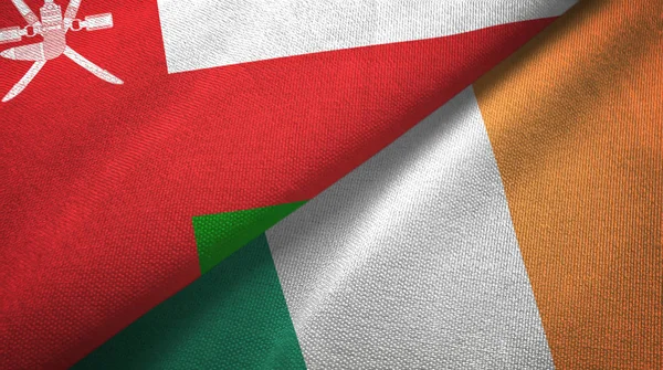 Omán e Irlanda dos banderas tela textil, textura de la tela —  Fotos de Stock