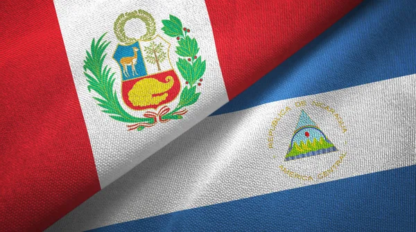 Peru e Nicarágua duas bandeiras de pano têxtil, textura de tecido — Fotografia de Stock