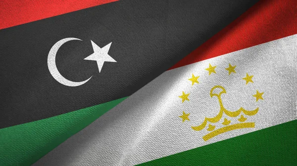 Líbia és Tádzsikisztán két zászló Textil szövet, szövet textúra — Stock Fotó