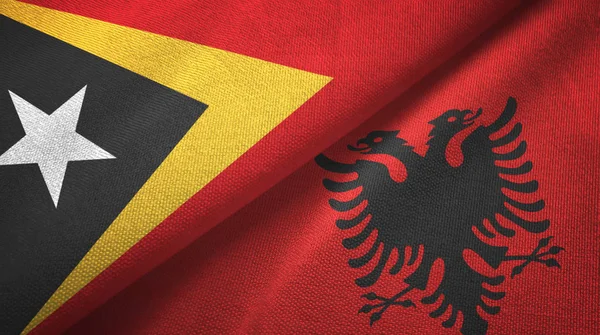 Oost-Timor en Albanië twee vlaggen textiel doek, weefsel textuur — Stockfoto