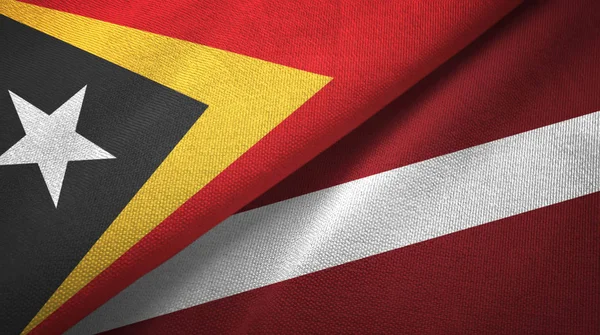 Oost-Timor en Letland twee vlaggen textiel doek, weefsel textuur — Stockfoto
