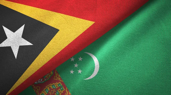 Timor Leste e Turquemenistão duas bandeiras tecido têxtil, textura de tecido — Fotografia de Stock