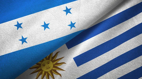 Honduras och Uruguay två flaggor textil trasa, tyg konsistens — Stockfoto