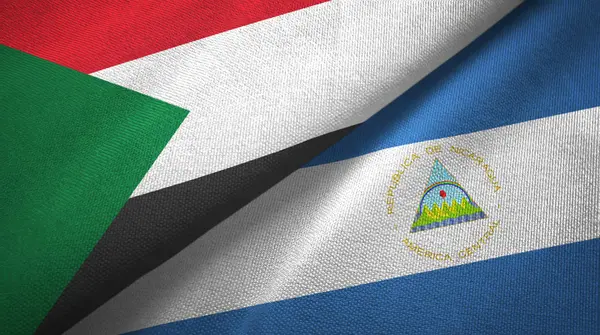 Sudán y Nicaragua dos banderas tela textil, textura de la tela — Foto de Stock