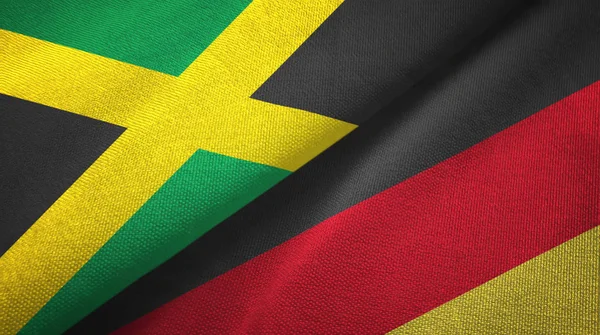 Jamaica és Németország két zászló textil ruhával, szövet textúra — Stock Fotó
