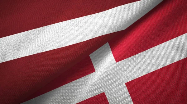 Letonia y Dinamarca dos banderas tela textil, textura de la tela —  Fotos de Stock