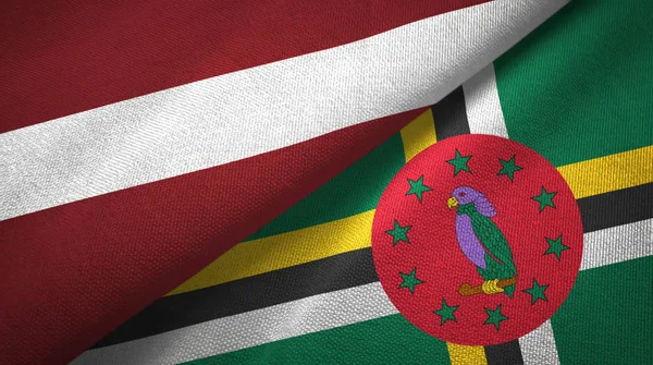 Lettonia e Dominica due bandiere tessuto, tessitura tessuto — Foto Stock